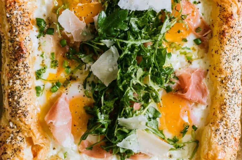 Baked prosciutto and egg breakfast tart served on a white plate