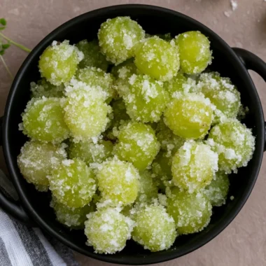 A bowl of candied frozen sour grapes, glistening with sugar crystals.