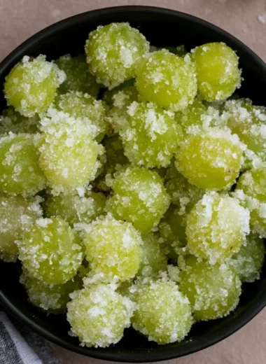 A bowl of candied frozen sour grapes, glistening with sugar crystals.