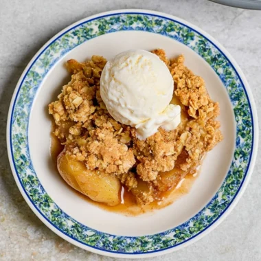 Delicious homemade apple crumble served in a dish, topped with crisp oats.