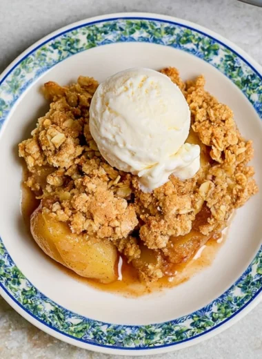 Delicious homemade apple crumble served in a dish, topped with crisp oats.