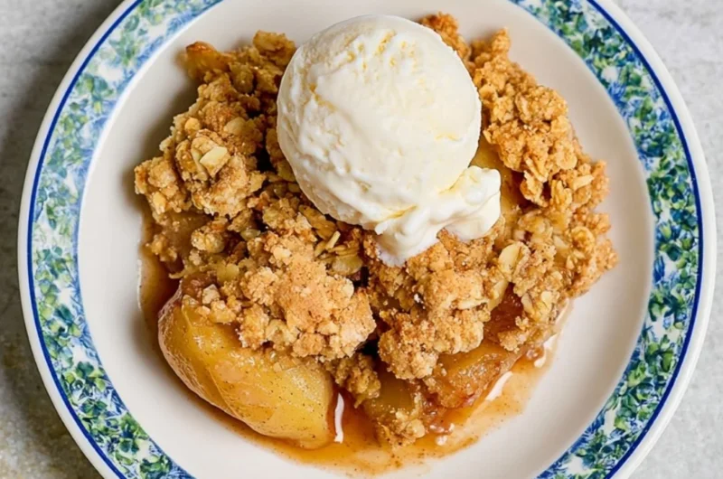 Delicious homemade apple crumble served in a dish, topped with crisp oats.