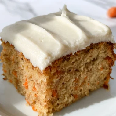 Dairy-free carrot cake with cream frosting on a rustic wooden table