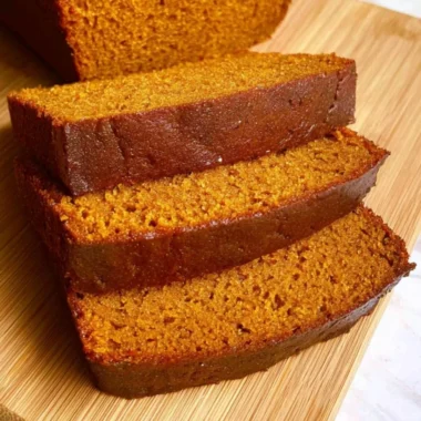 Homemade easy pumpkin bread loaf displayed on a wooden table.