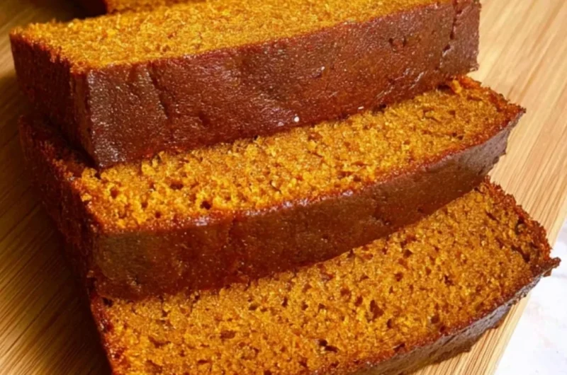 Homemade easy pumpkin bread loaf displayed on a wooden table.