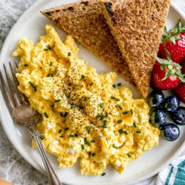 Plate of high-protein scrambled eggs with cottage cheese and herbs