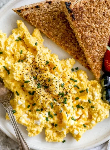 Plate of high-protein scrambled eggs with cottage cheese and herbs
