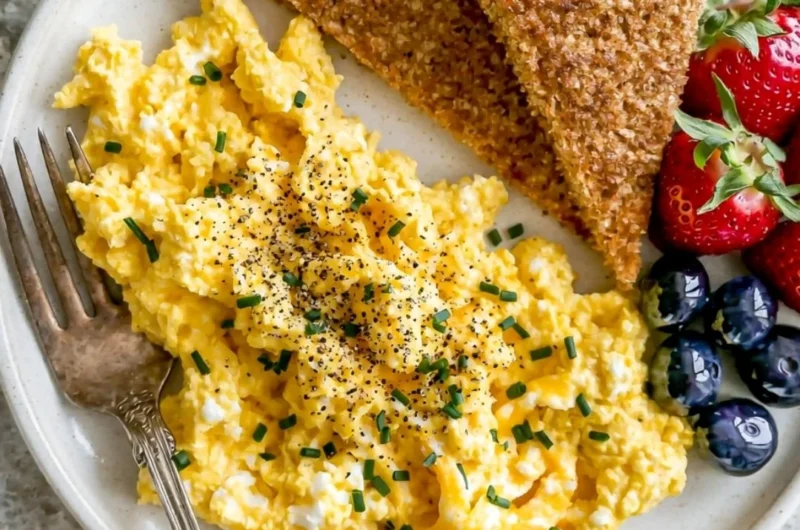 Plate of high-protein scrambled eggs with cottage cheese and herbs