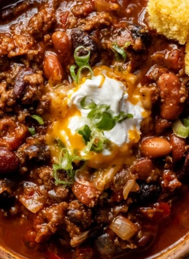 Bowl of delicious chili topped with cheese and herbs