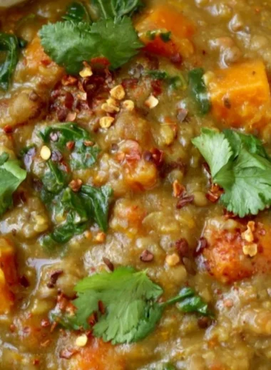 Bowl of earthy Moroccan sweet potato lentil stew with spices and fresh herbs.