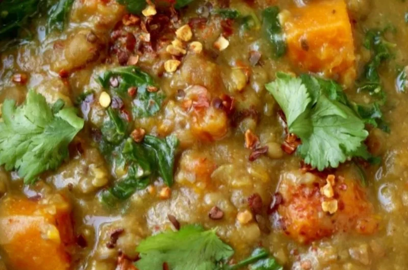Bowl of earthy Moroccan sweet potato lentil stew with spices and fresh herbs.