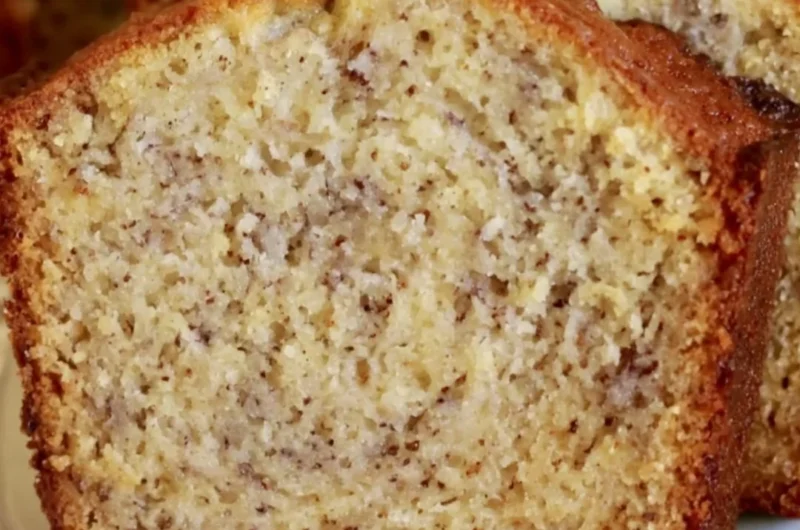 Loaf of perfect banana bread with sliced bananas on a wooden table