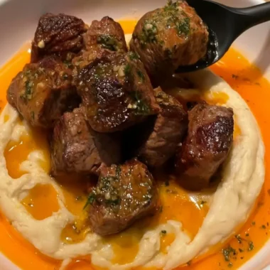 Cowboy Butter Steak Bites with caramelized onions served on a plate