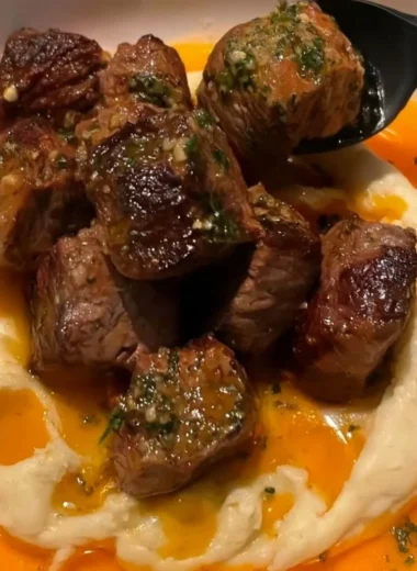 Cowboy Butter Steak Bites with caramelized onions served on a plate