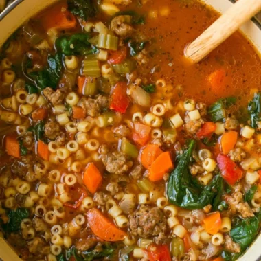 Bowl of hearty Italian sausage soup with vegetables and herbs