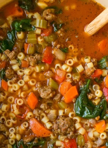 Bowl of hearty Italian sausage soup with vegetables and herbs