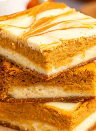 Delicious Pumpkin Cream Cheese Cheesecake Bars topped with whipped cream.