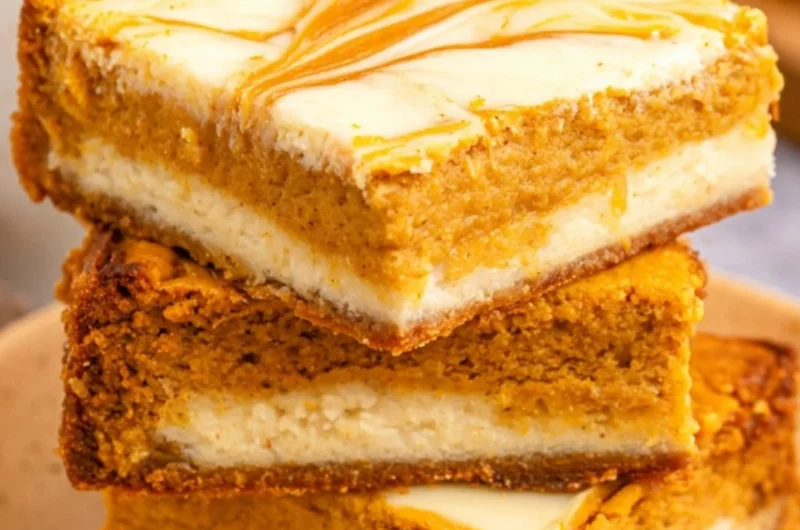 Delicious Pumpkin Cream Cheese Cheesecake Bars topped with whipped cream.