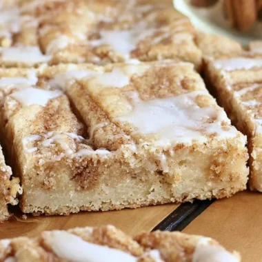 Delicious cinnamon roll cookie bars with icing on a plate