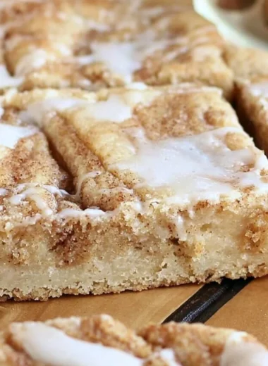Delicious cinnamon roll cookie bars with icing on a plate