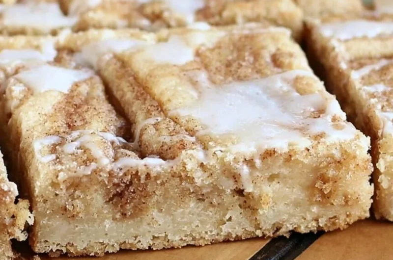 Delicious cinnamon roll cookie bars with icing on a plate
