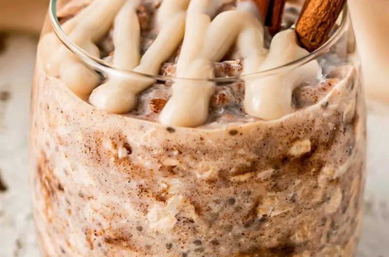 Bowl of cinnamon roll overnight oats topped with cinnamon and nuts.