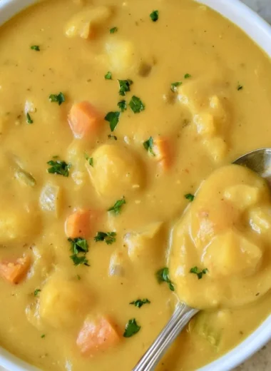 Bowl of creamy German potato soup garnished with fresh herbs