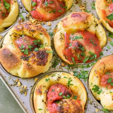 Meatball stuffed garlic bread served on a platter, topped with herbs.