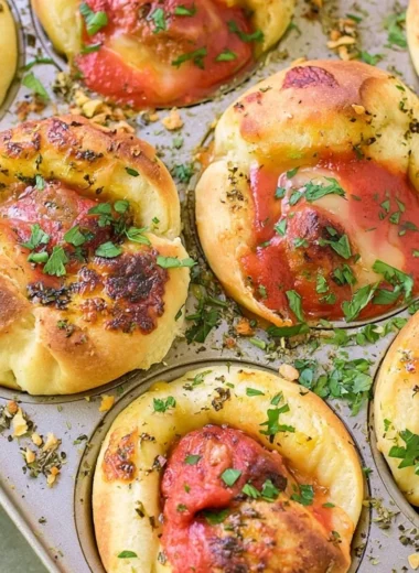 Meatball stuffed garlic bread served on a platter, topped with herbs.
