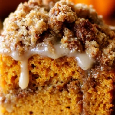 Pumpkin coffee cake with streusel topping on a rustic wooden table