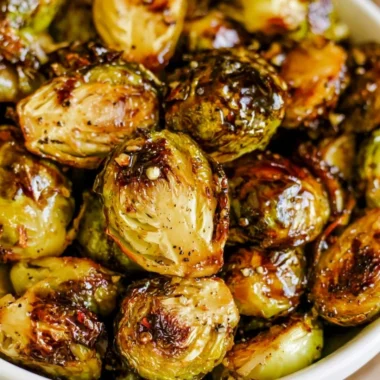Plate of roasted Brussels sprouts with honey balsamic sauce drizzled on top.
