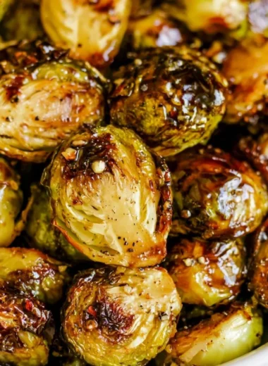 Plate of roasted Brussels sprouts with honey balsamic sauce drizzled on top.