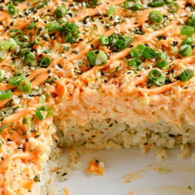 Baked Salmon Sushi served in a casserole dish with fresh ingredients and toppings.