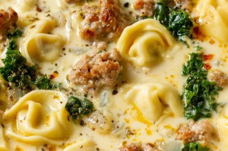 Bowl of delicious Sausage Tortellini Soup with herbs and cheese.