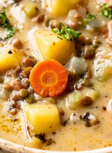 Delicious bowl of vegetarian lentil soup served in a rustic kitchen bowl.